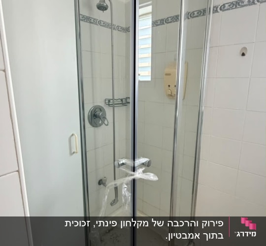 מקלחון פינתי בחדר אמבטיה עם דלתות זכוכית